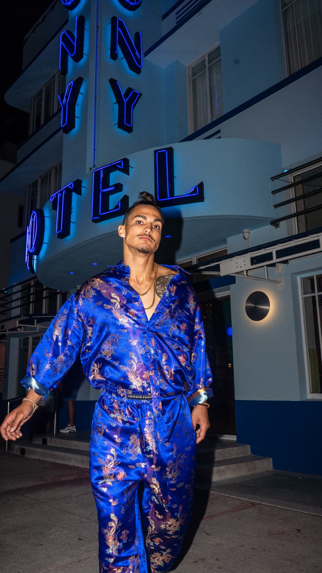 Cobalt brocade set photographed under neon hotel signage
