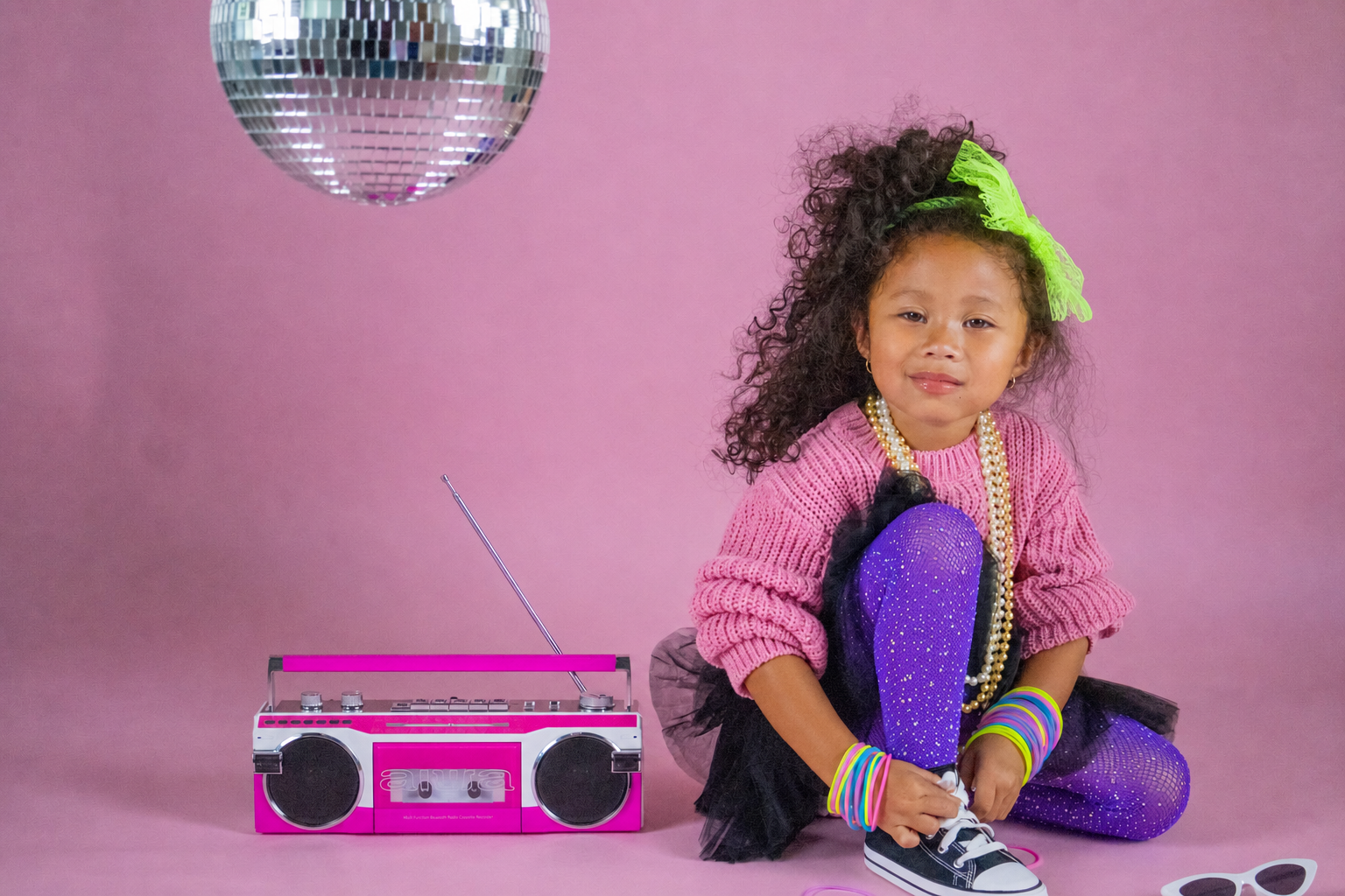 Milani’s World homepage image: child in a pink editorial setting with a radio and disco ball