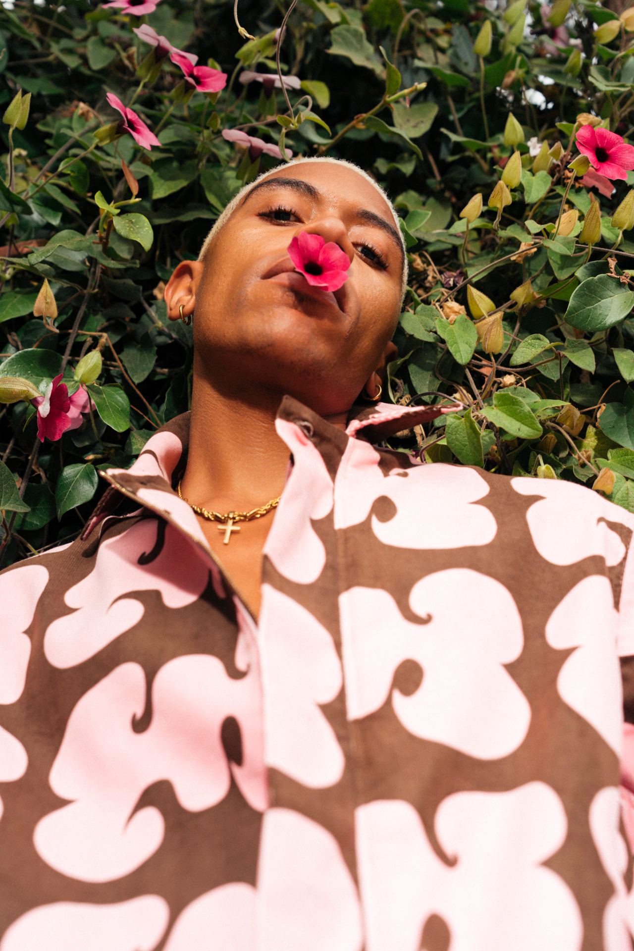 Pink and brown swirl-print corduroy shirt photographed against flowering vines