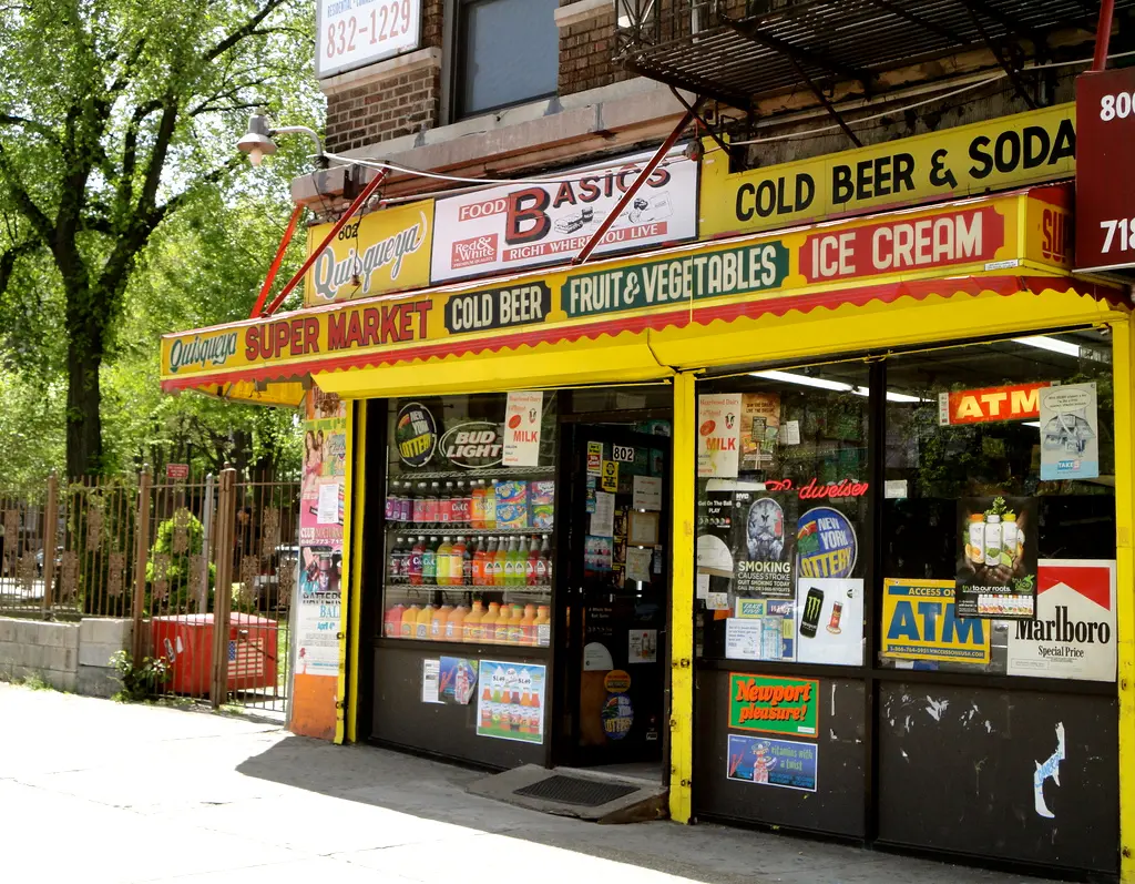 A New York corner bodega with hand-painted signage and awnings.