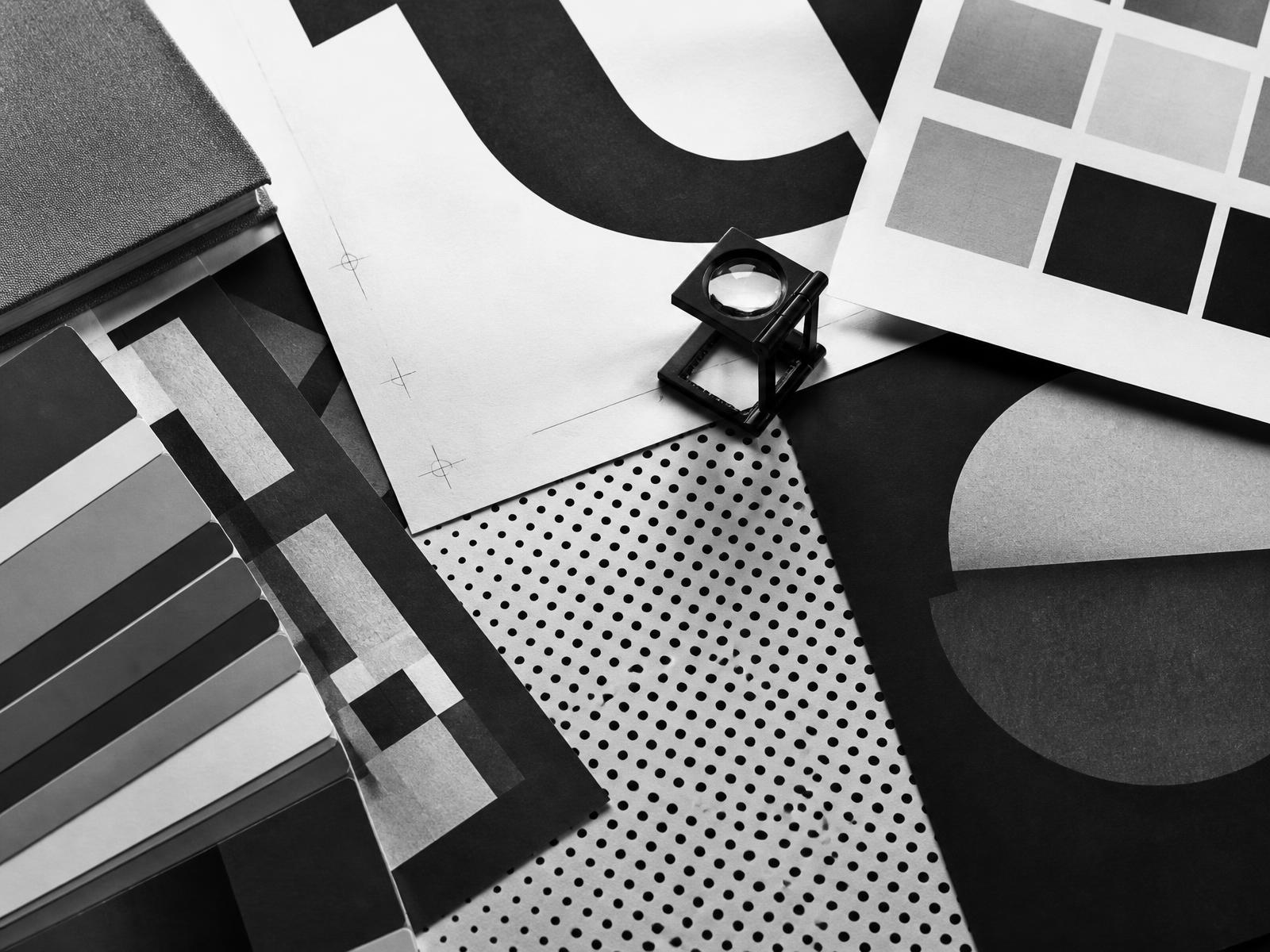 Printed proofs, type specimens and grey swatch chips arranged on a studio table